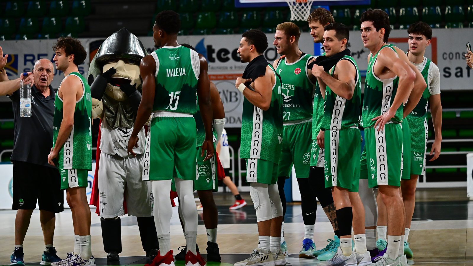 Los jugadores del Cáceres, con la mascota, en el centro de la pista del Multiusos tras ganar al Logrobasket